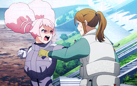 Duas personagens de anime lutando, uma com cabelo rosa em um traje cinza e outra com cabelo castanho em um traje branco. Ambas parecem estar em um ambiente urbano.